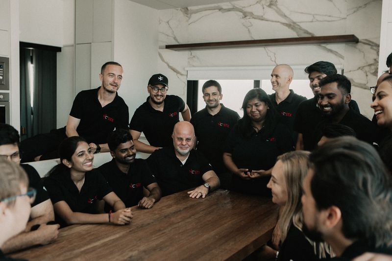 The sophisTex team laughing together around a wooden table